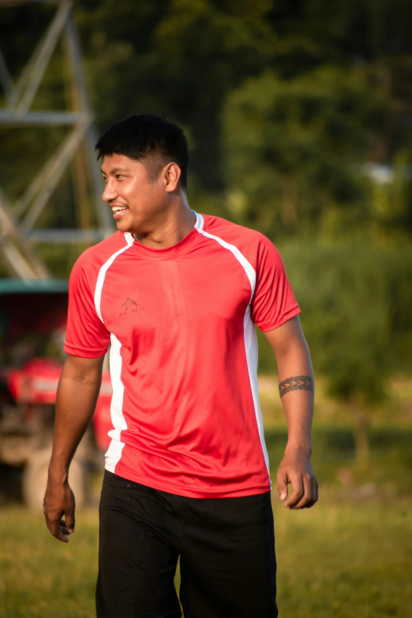 man in red shirt in grass next to truck