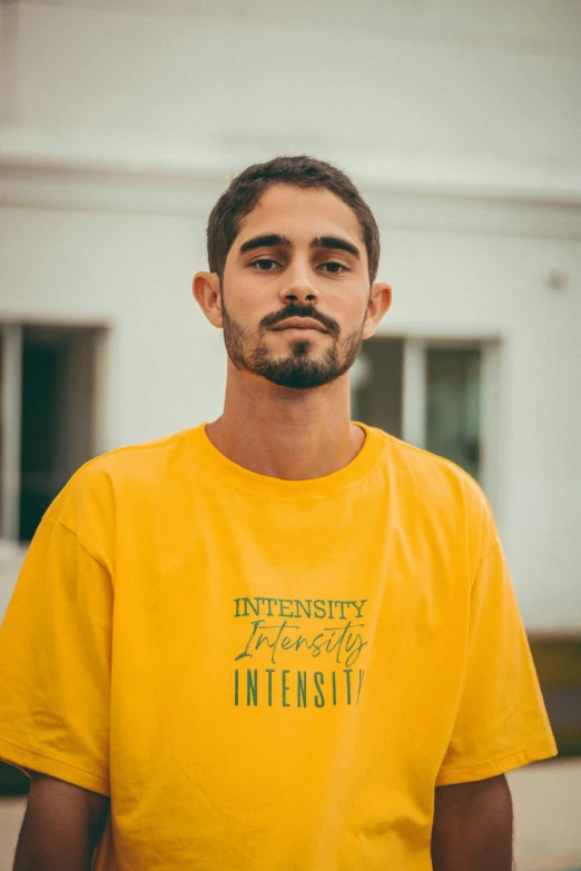 a young man posing for a picture wearing a yellow tshirt