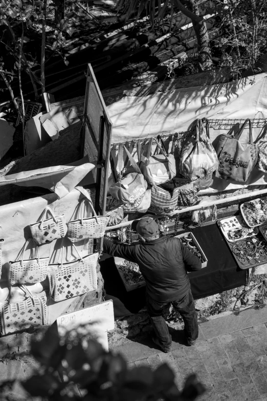 man standing next to wooden goods with his hand