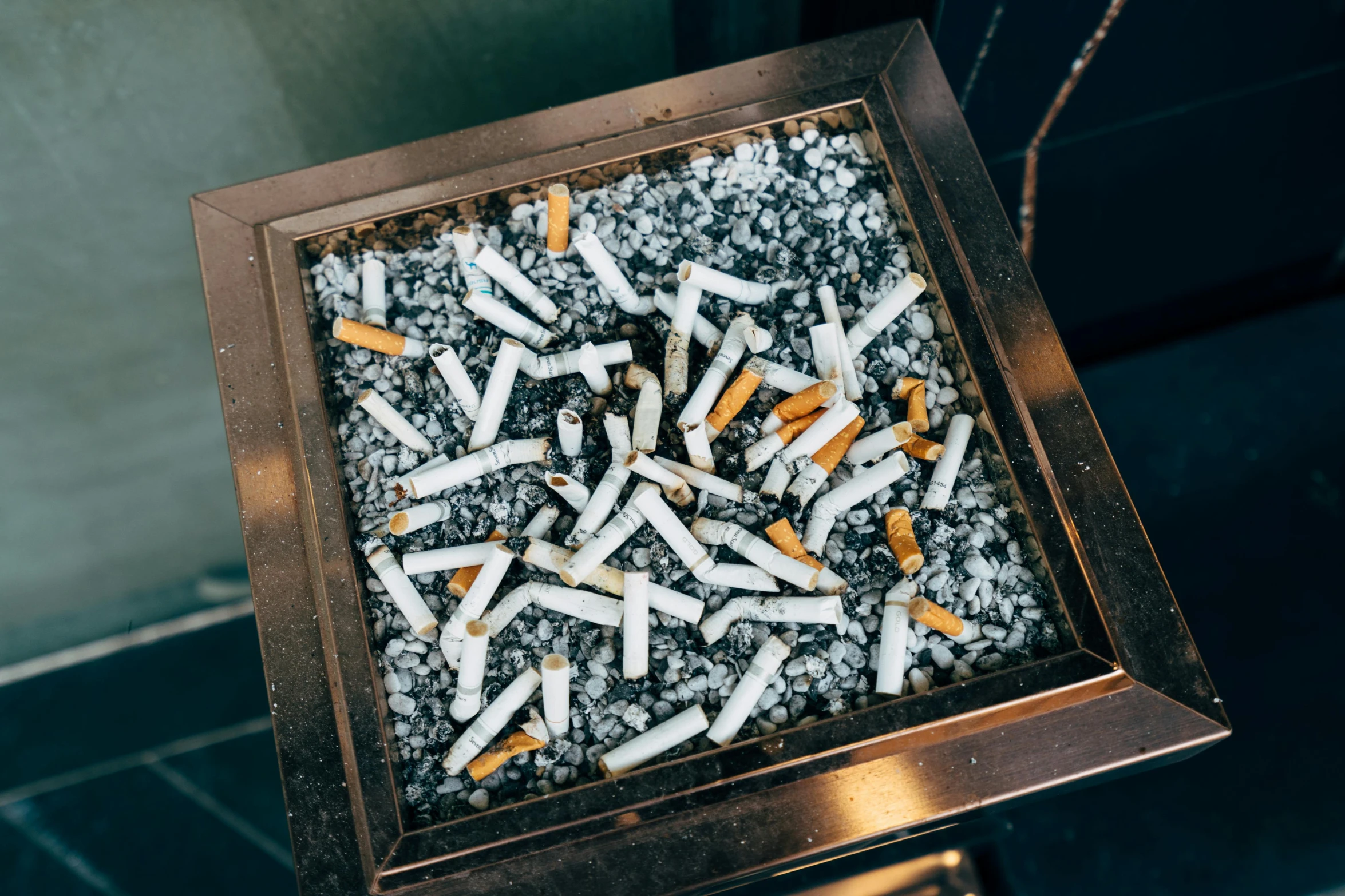 a box with a cigarette on it surrounded by lots of white cigarettes