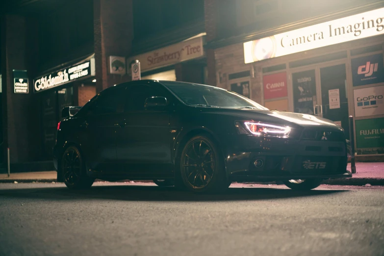 a car parked on the side of a street next to a brick building