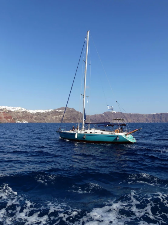 small boat sailing near a rocky coastline on open water