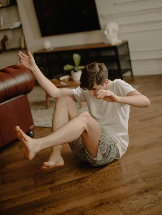 a person sitting on the floor with their feet in the air