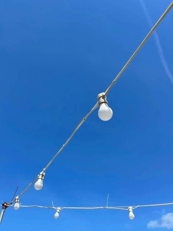 a pair of white lights against a clear blue sky