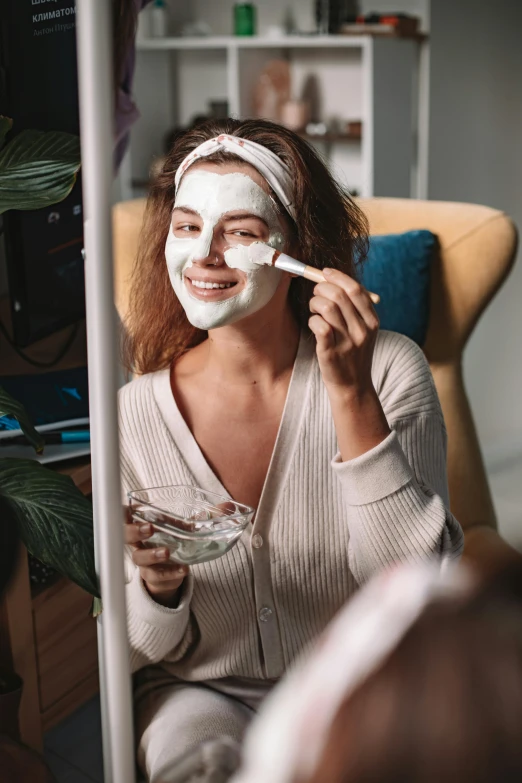 woman in white face mask putting in some whipped cream on her face