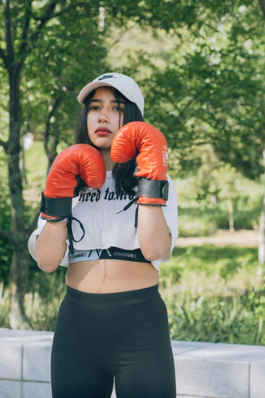 a woman wearing boxing gloves and a white shirt