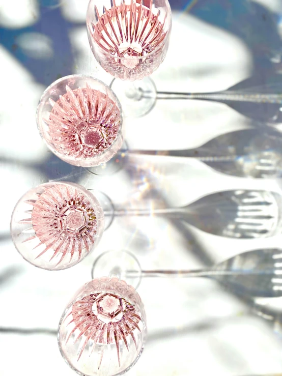 three glass goblets are on a glass table