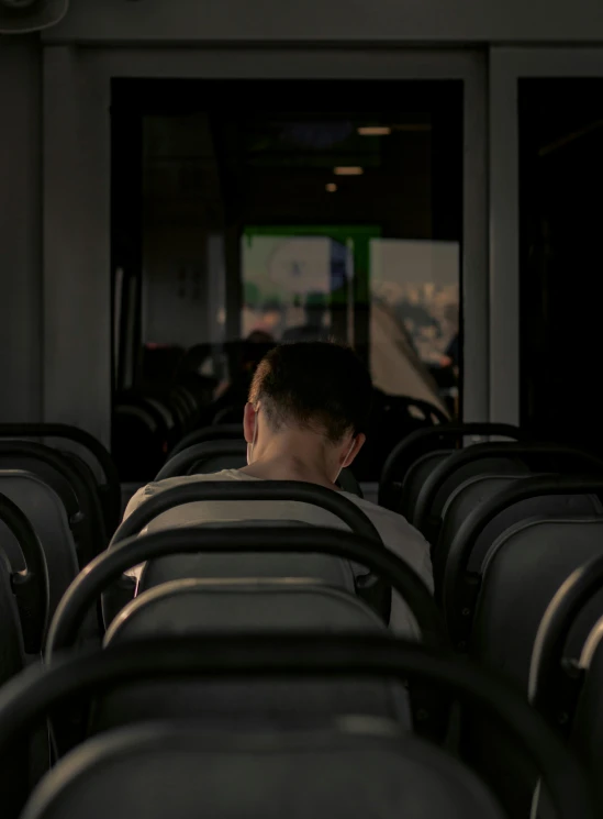 a man standing at the back of a row of bus seats