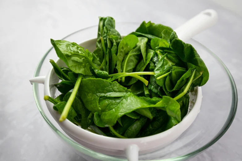 some spinach are in a bowl on a table