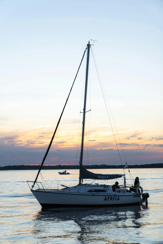 a sailboat in a body of water at sunset