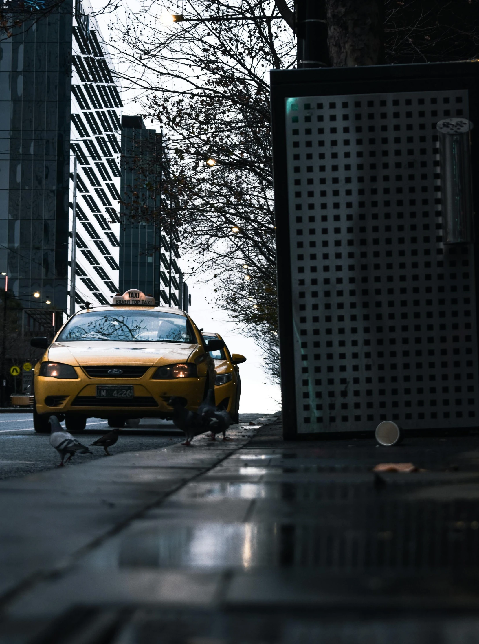 a yellow taxi cab parked on a side walk