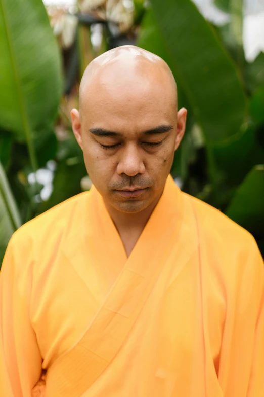 a bald man in an orange outfit standing