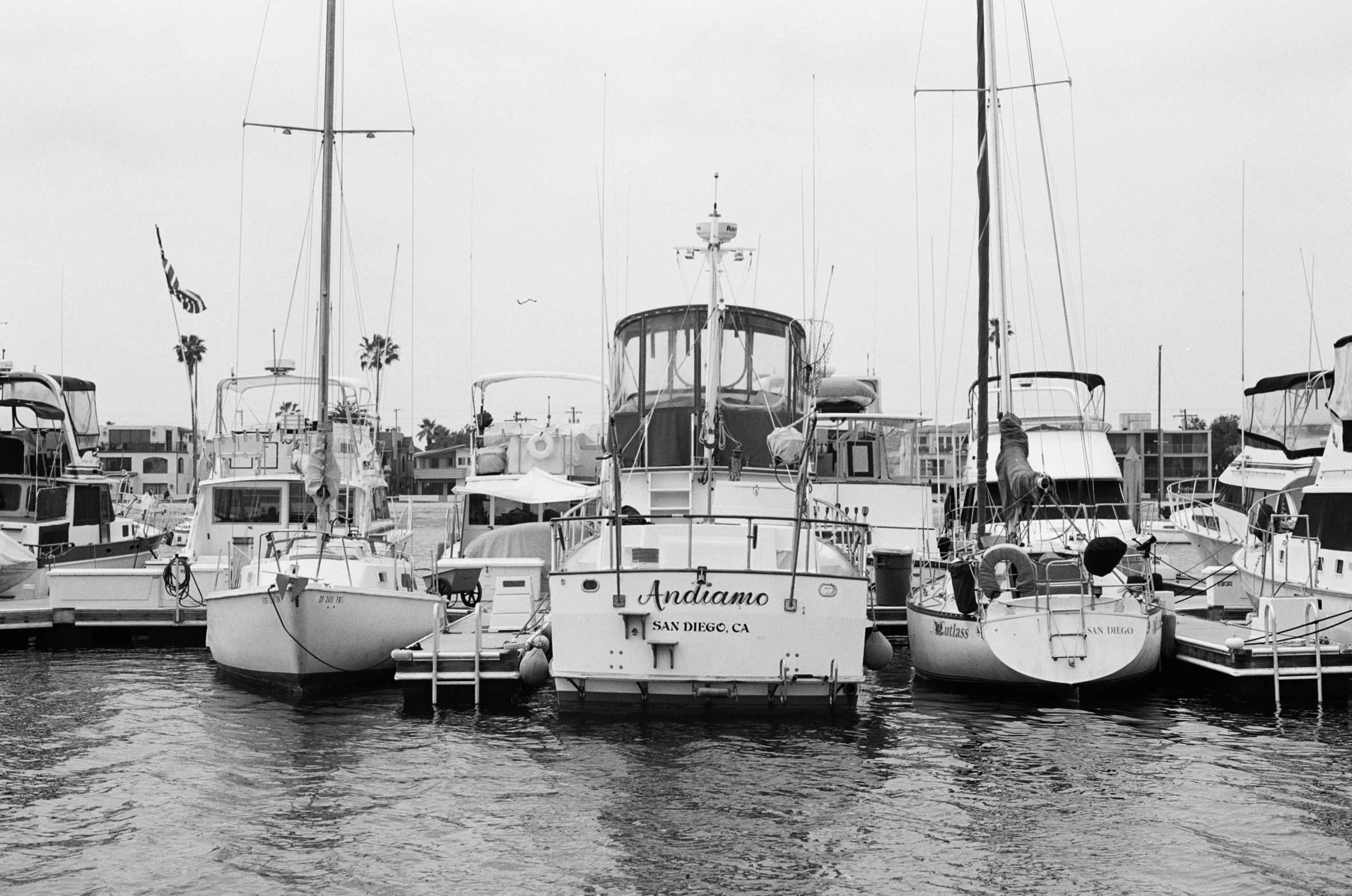 boats docked at a pier with flags hanging on them