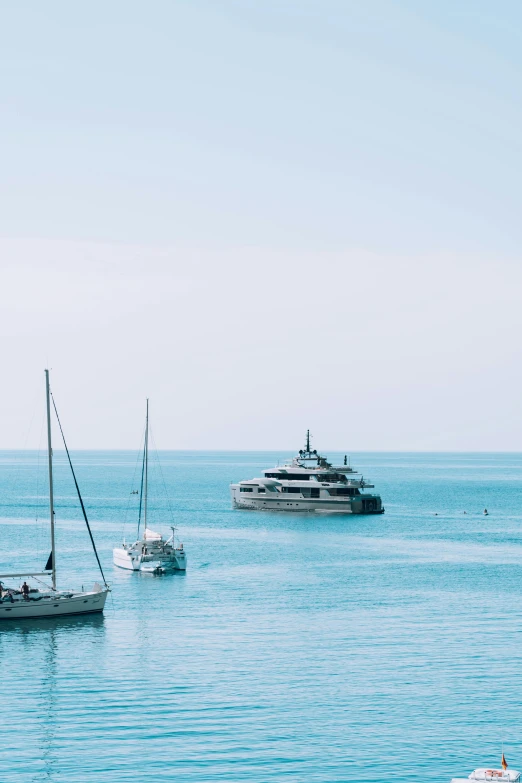 two boats in the ocean and a yacht nearby