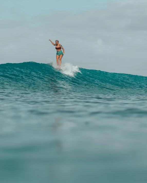 a woman riding on top of a wave in the ocean