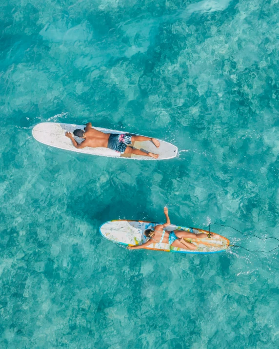 two people paddle boards in a blue water