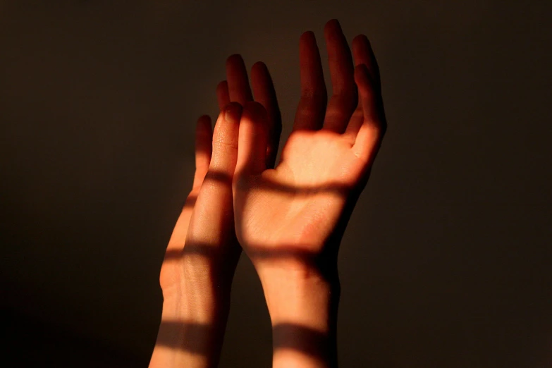 a po of someone's hands that have their hands extended to the ceiling
