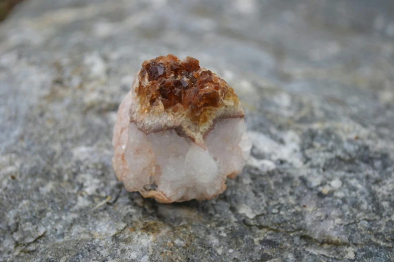 there is a rock with a small quartz and various different crystals on it