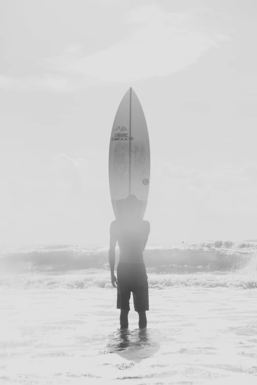 a man that is standing in the water with a surfboard