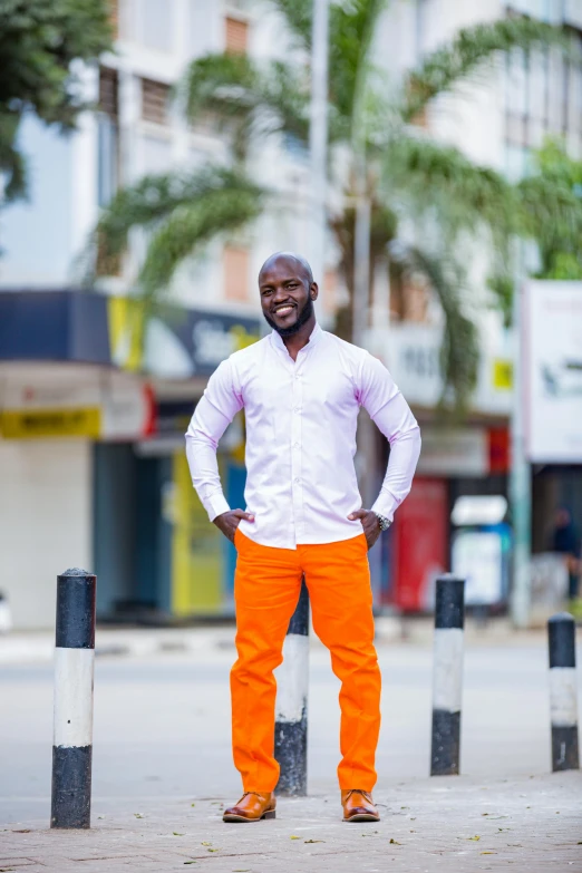 man with orange pants standing in front of a tall building