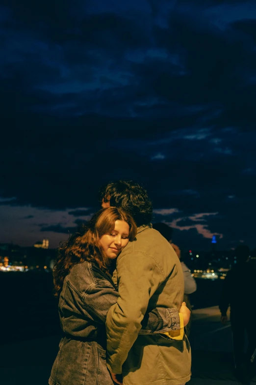 man and woman emcing at the ocean at night