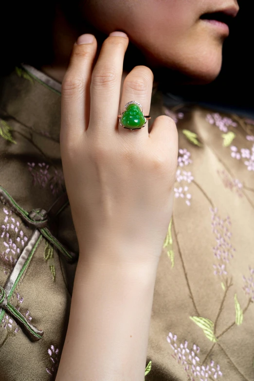 there is a woman's emerald ring on her finger