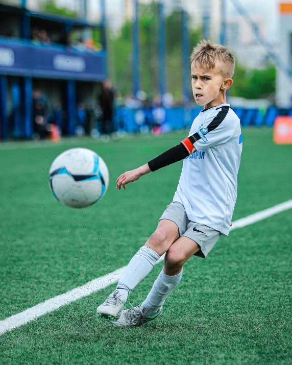 the young soccer player is trying to kick the ball