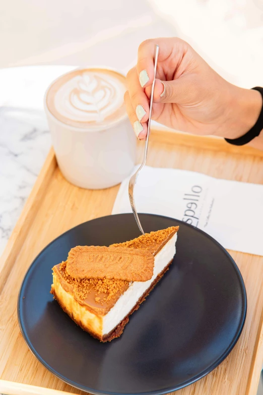 someone eating a piece of cake on a black plate