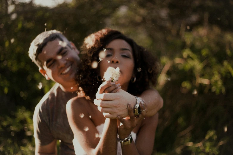 a man and woman are blowing confetti on each other