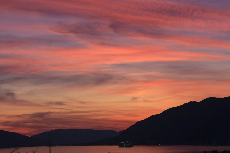 a boat is sitting on the water as the sunsets