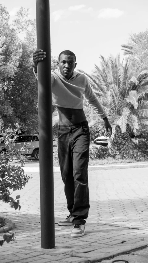 a black man standing next to a pole with a basketball in his hand