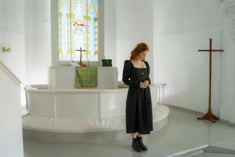 a woman standing in front of the cross in the sanctuary