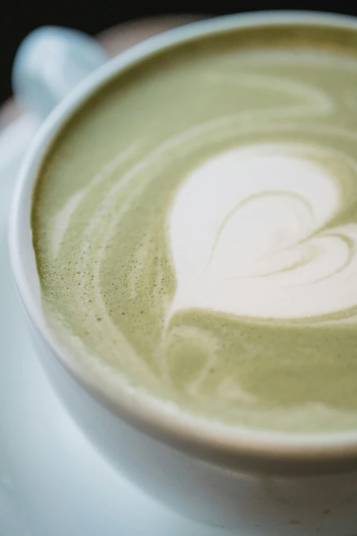 there is a cup of coffee that has heart shaped liquid in it