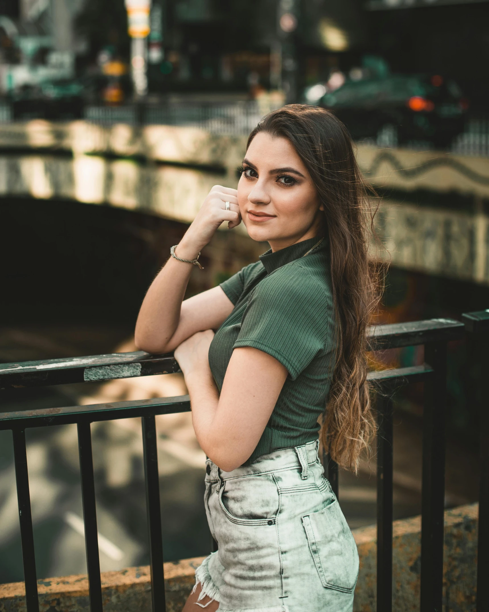 a woman standing near a railing and looking at the camera