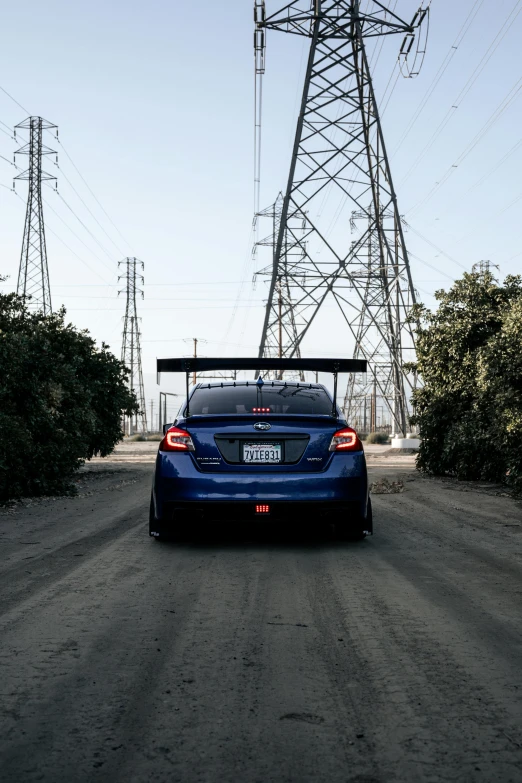 a blue car is driving down the road