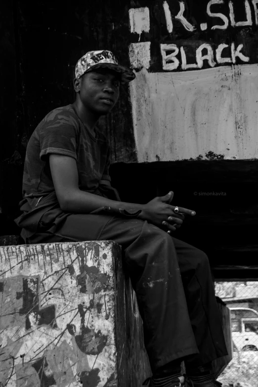 a man with a hat on sitting by himself