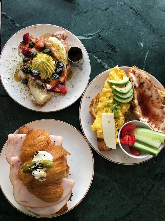 four different plates of food on top of a green table