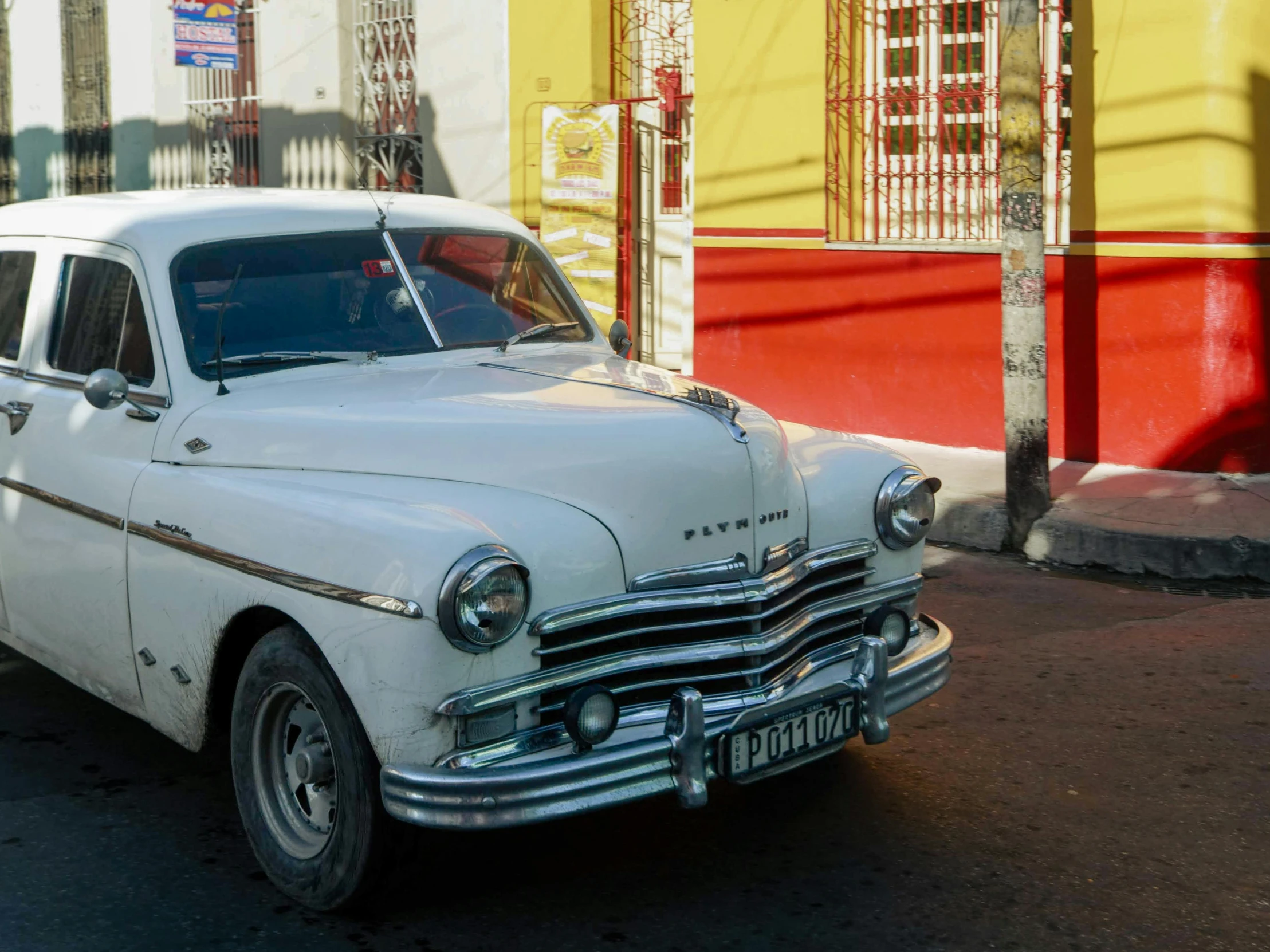 an old classic car parked on the side of the street