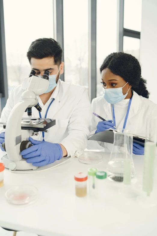 two doctors looking at soing through a microscope