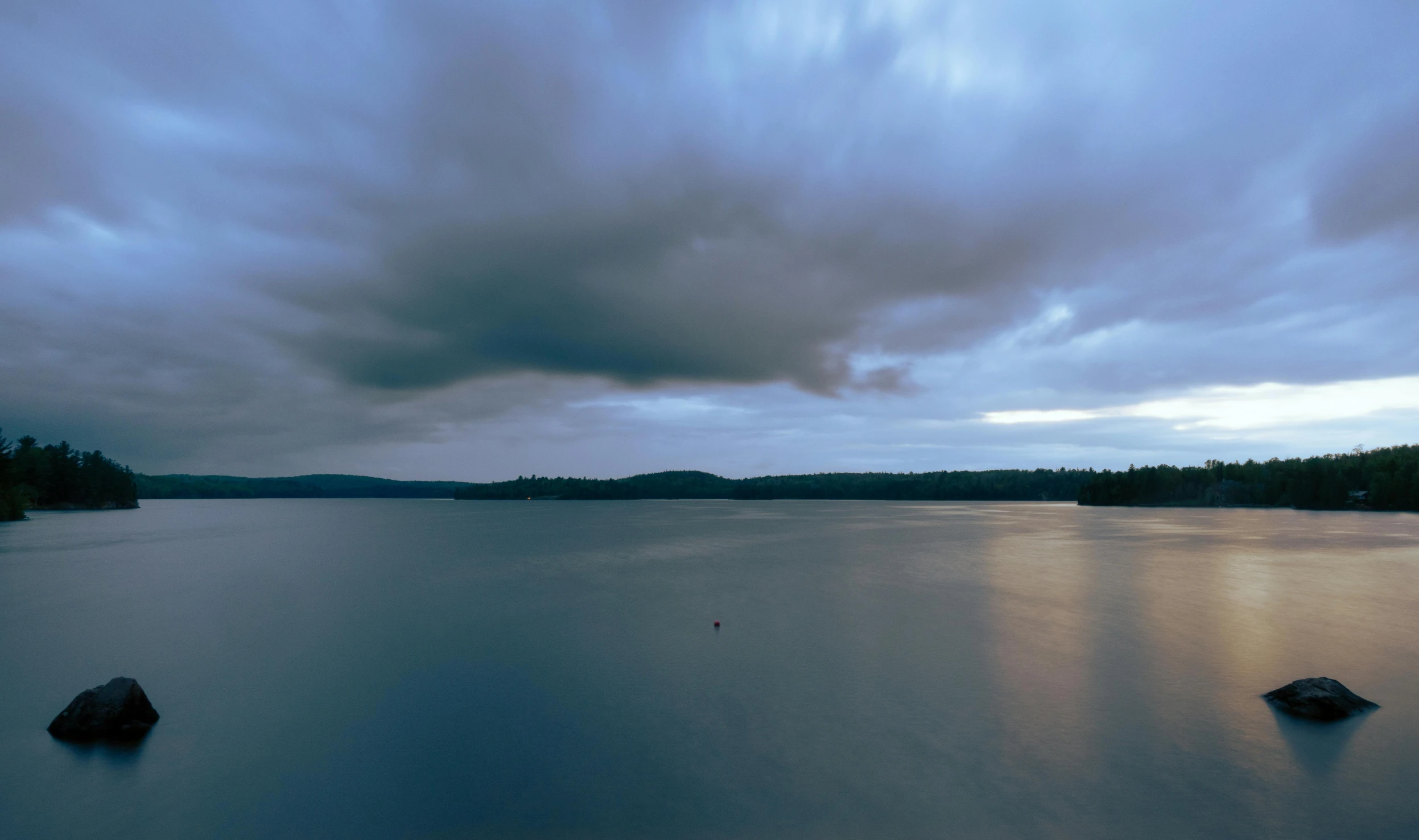 the ocean during a dark cloudy day near some rocks