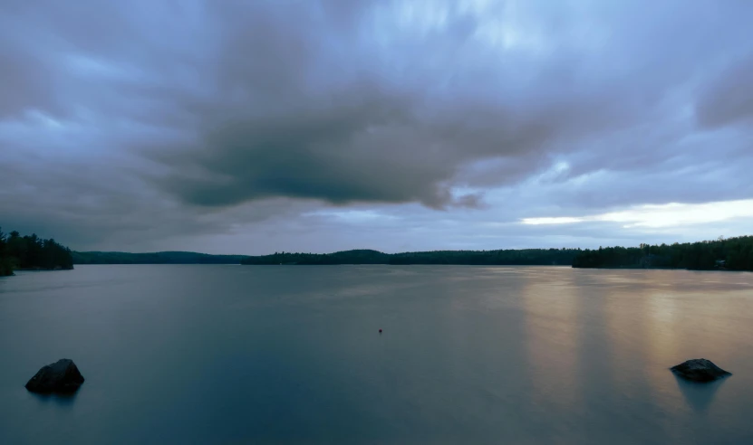 the ocean during a dark cloudy day near some rocks