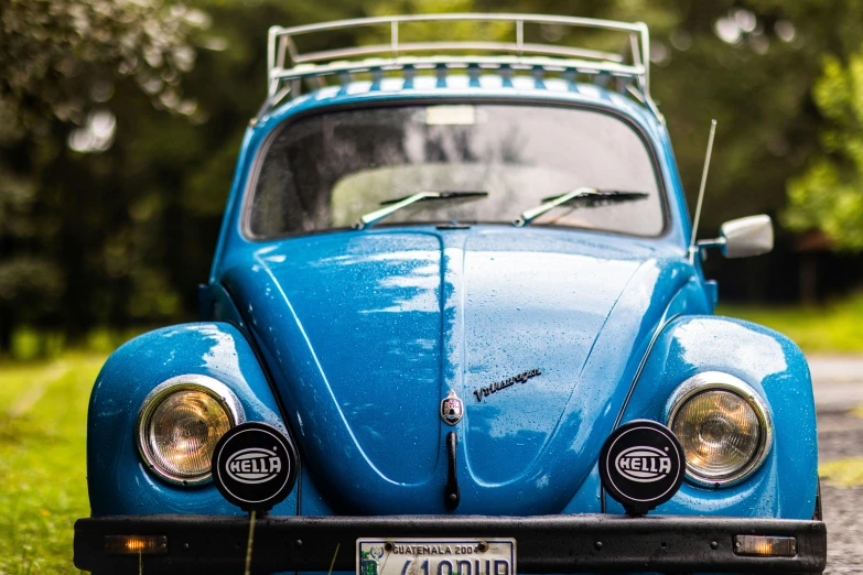 the back end of a small blue car with lights