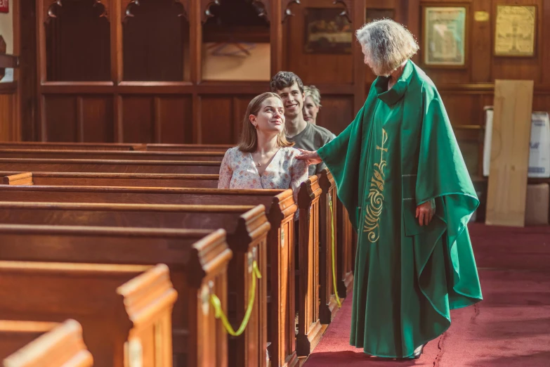 some people stand around in pews at a church