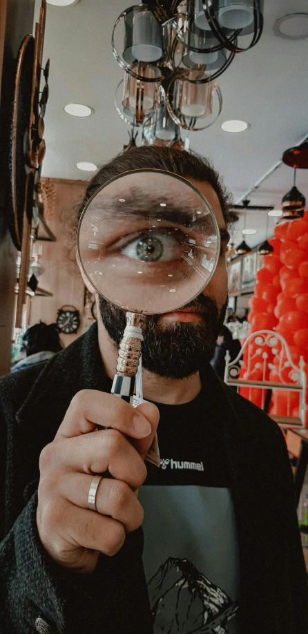a man is holding a magnifying glass up to his eye