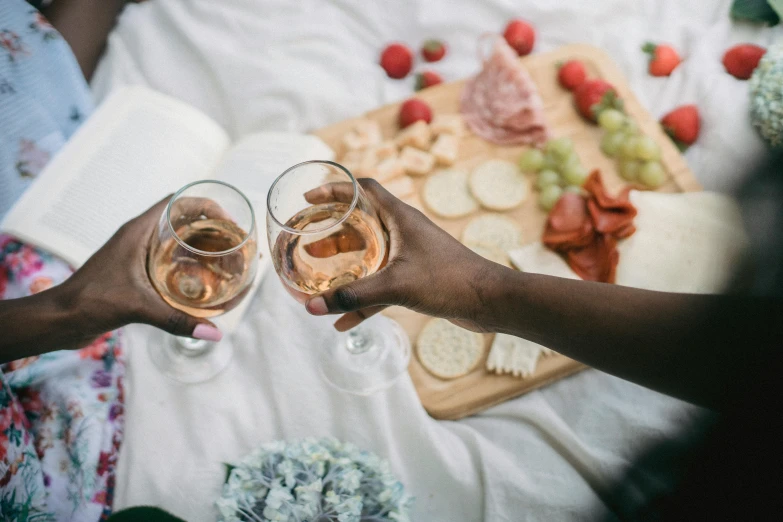 a person with their hands full of champagne toasting together