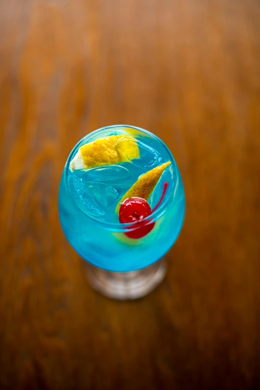 a blue glass sitting on top of a wooden table