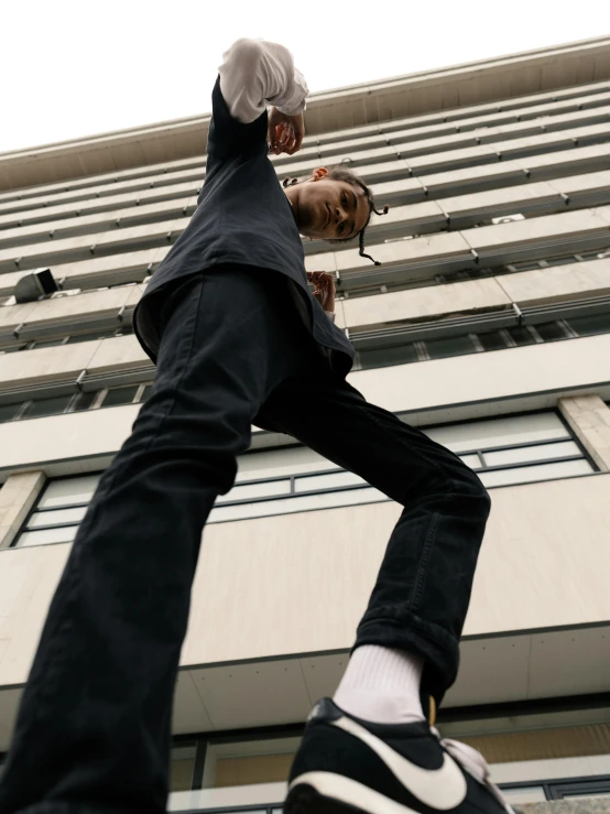 person wearing dark clothing standing near large building