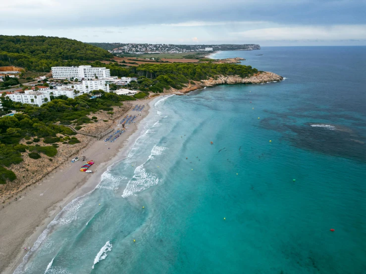 a group of people walking along a sandy beach