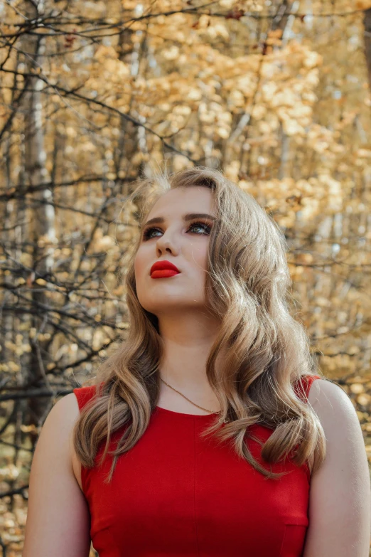 woman in red dress with trees behind her