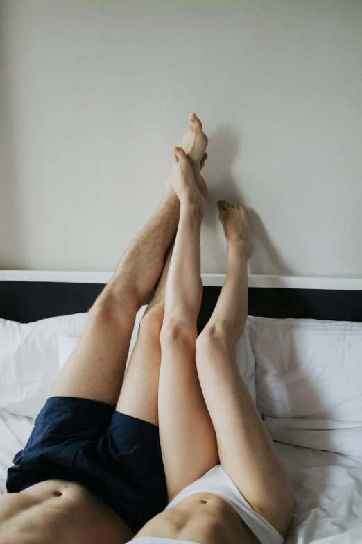 a person lying on a bed and stretching their legs